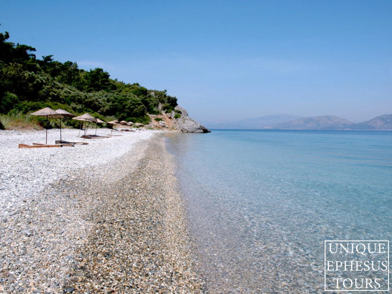 pebbled-beach-with-straw-umbrellas-turkey